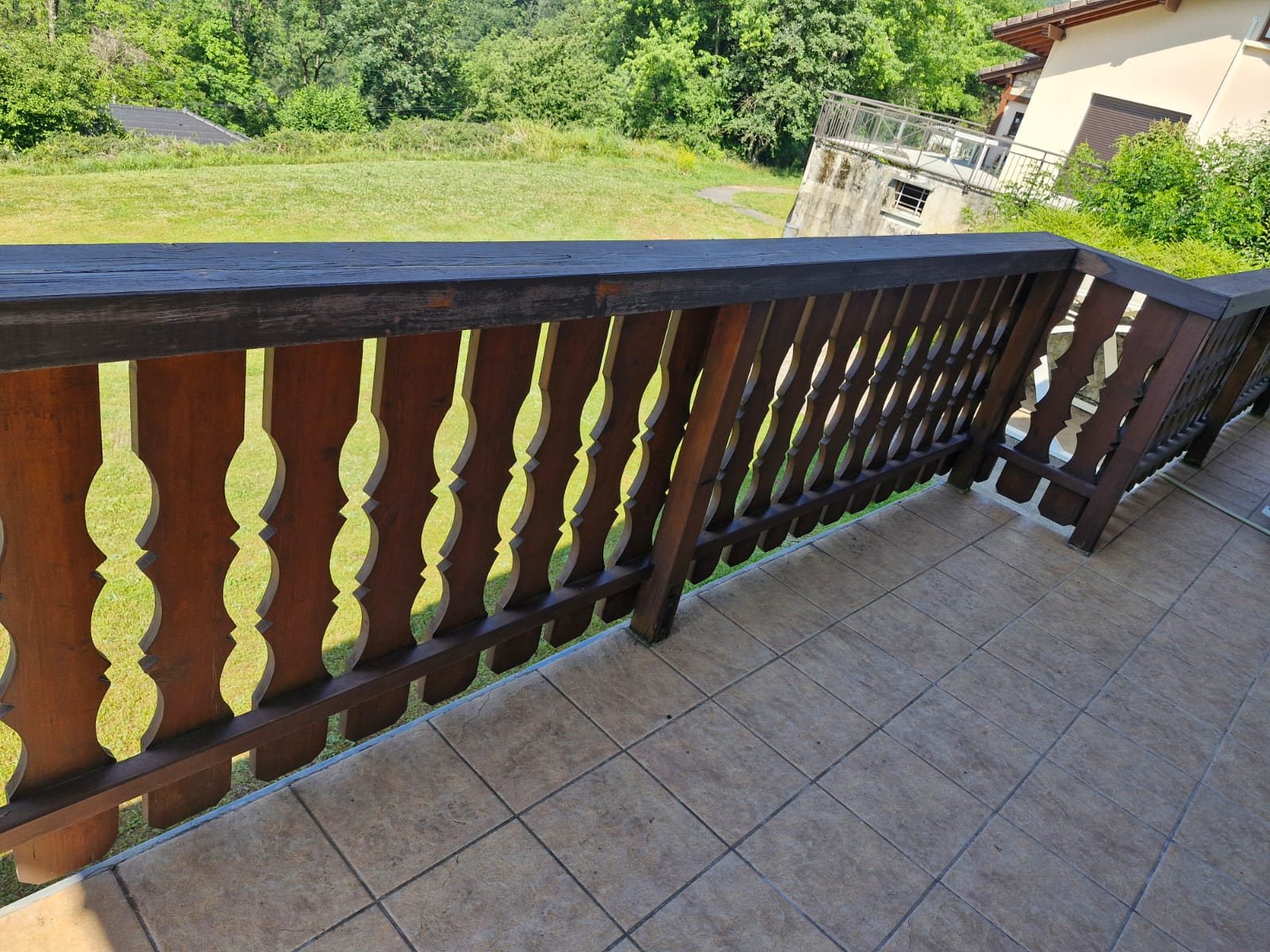Avant : garde-corps de balcon en bois, main courante noircie