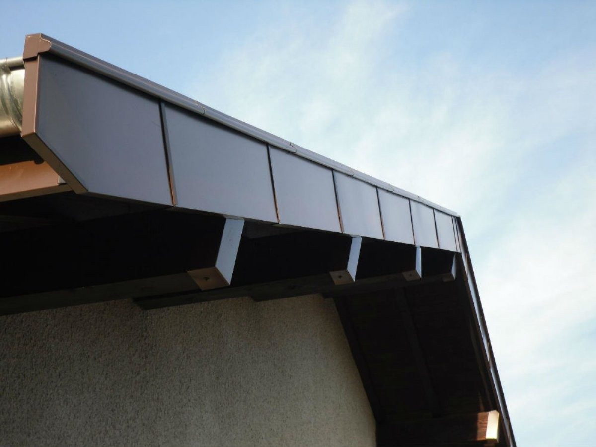 Planches de rive habillées d'aluminium gris sur le pignon d'une maison.