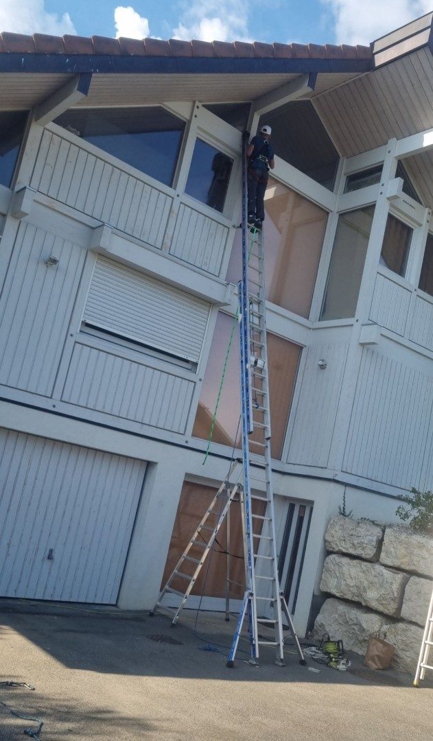Bardage de façade en cours de peinture, échelle contre le mur.